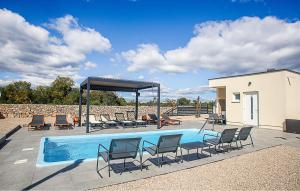 a swimming pool with lounge chairs and a gazebo at 3 Bedroom Nice Stacaravan In Drnis in Brištane