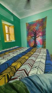 a bedroom with a painting of a tree on the wall at Anand hostel in Pushkar +19 photos