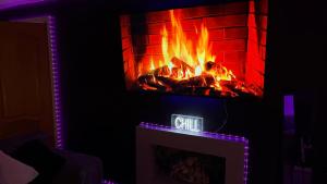 a living room with a fireplace with a fire at A Star Living in Liversedge +10 photos