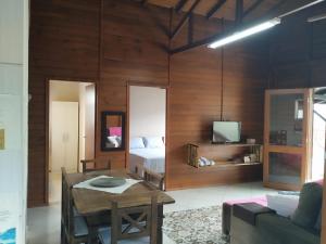 a living room with a bed and a table at Chalé da Val in Palhoça