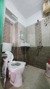 a bathroom with a pink toilet and a sink at Anand hostel in Pushkar