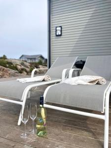 two beds with wine glasses and a bottle of wine at House by the fjord - Ocean view and jacuzzi in Forland