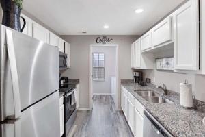 a kitchen with white cabinets and a white refrigerator at Rockwall Lodge - Close to Branson Strip in Branson