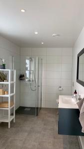 a bathroom with a shower and a sink at House by the fjord - Ocean view and jacuzzi in Forland