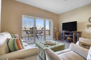 een woonkamer met banken, een tv en een open haard bij Lakefront Sanctuary - Table Rock Lake Adventures in Branson