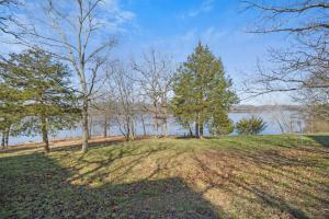 een grasheuvel met bomen en water bij Lakefront Sanctuary - Table Rock Lake Adventures in Branson