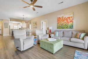 een woonkamer met een bank en stoelen en een plafondventilator bij Lakefront Sanctuary - Table Rock Lake Adventures in Branson