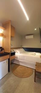 a bedroom with two beds and a table and a kitchen at Hospedagem Moderna em Container in Foz do Iguaçu