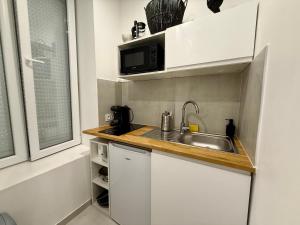 eine kleine Küche mit Spüle und Mikrowelle in der Unterkunft Cocon magic-Jacuzzi & Netflix in Villeurbanne + 7 Fotos