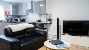 un salon avec un canapé en cuir noir et une table dans l'établissement Reardon Apartment Warwick - Sleeps 5 - Parking & Wifi, à Warwick