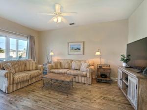 a living room with two couches and a flat screen tv at South Beach Retreat in Tybee Island
