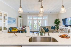 a kitchen with a sink and a living room at 517 The Southend Pier House in Virginia Beach
