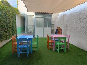 a group of colorful tables and chairs on a patio at Jardin 85 Hostel in Morelia