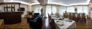 a living room with a couch and a table at Pensiunea Görgő Panzió in Sfântu-Gheorghe