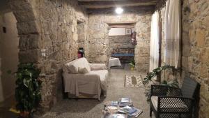 a living room with a white couch and a stone wall at Casa Camilla Sardegna in San Vito