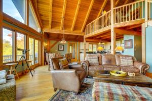 una sala de estar con muebles de cuero y techo de madera. en 4 Mi to Stratton! Group Getaway with Deck and Views, en Stocker Acres