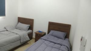 two beds sitting next to each other in a room at شقه غرفتين وصاله الاربعين in Riyadh