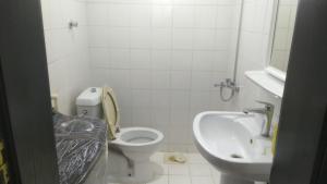 a white bathroom with a toilet and a sink at شقه غرفتين وصاله الاربعين in Riyadh