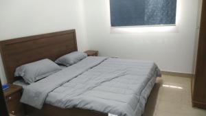 a bedroom with a large bed with a wooden headboard at شقه غرفتين وصاله الاربعين in Riyadh