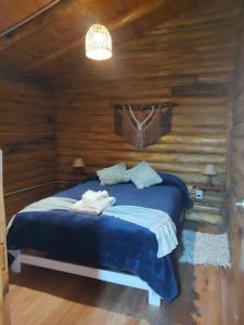a bedroom with a bed in a log cabin at Refugio Doña Josefa, cabaña de montaña La Cumbrecita in La Cumbrecita