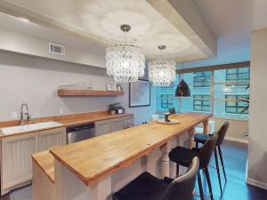 a kitchen with a large wooden table and chandeliers at Drayton Escape in Savannah