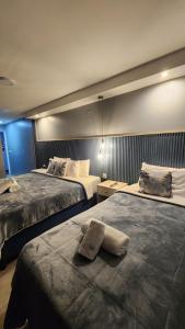 a hotel room with two beds with towels on them at Essencial Hotel Spa in Mendoza +17 photos