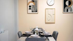 a dining room with a table with chairs and a clock at Langcliffe House - 3 Bed, Sleeps 5 - Garden, Parking & Wifi - Warwick in Warwick