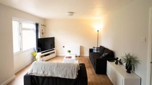 a living room with a couch and a tv at Langcliffe House - 3 Bed, Sleeps 5 - Garden, Parking & Wifi - Warwick in Warwick