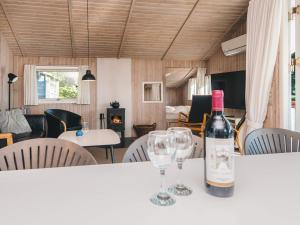 a bottle of wine sitting on a table with two wine glasses at Seaside Haven with Spa - By Traum Ferienwohnungen in Sønder Bjert +19 photos