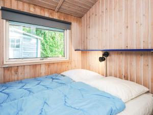 a bed in a wooden room with a window at Seaside Haven with Spa - By Traum Ferienwohnungen in Sønder Bjert