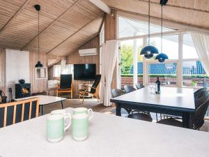 a living room with a table and a dining room at Seaside Haven with Spa - By Traum Ferienwohnungen in Sønder Bjert