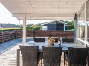 a patio with a table and chairs on a deck at Seaside Haven with Spa - By Traum Ferienwohnungen in Sønder Bjert
