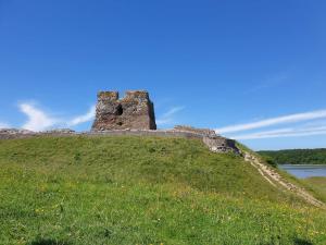 an old castle on top of a grassy hill at 7 person holiday home in Kolind-By Traum in Kolind