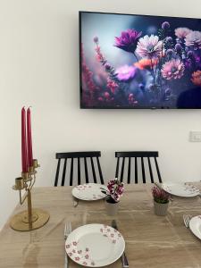 a table with two chairs and a painting on the wall at Red Sea Harmony - by G&P Suites in Eilat