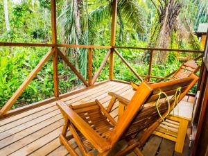 two chairs and a table on a wooden porch at Amazon Planet in Tambopata