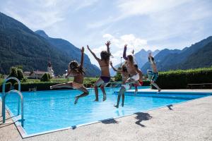 a group of people jumping into a swimming pool at Pension Fuchs in Pfunds
