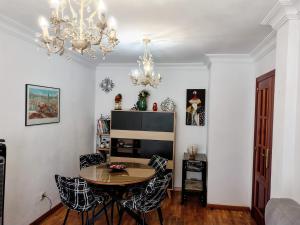 a dining room with a table and chairs and a chandelier at Confortable y luminoso apartamento in Valladolid +6 photos