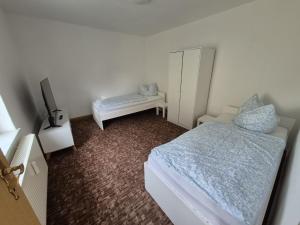 Un dormitorio pequeño con una cama y un televisor. en Monteurwohnung nähe Leuna, Halle und Leipzig, en Braunsbedra