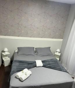 a bedroom with a bed with two towels on it at Loft Centro - No Calçadão e em frente Parque das Águas in São Lourenço