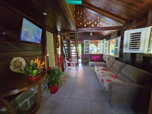 a living room with a couch and a flat screen tv at Chalet Plage et Kite in Le Vauclin
