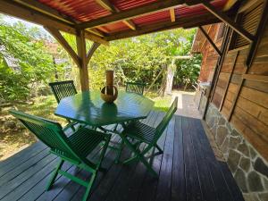 a table and chairs on a porch with a vase on it at Chalet Plage et Kite in Le Vauclin