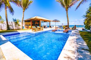 a swimming pool with palm trees and a gazebo at Mar a Vista Charme by Concavus in Porto De Galinhas