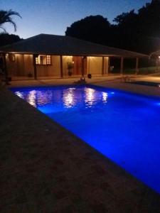 a swimming pool with blue lights in front of a house at Hotel Kaeru in Avaré