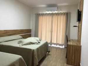 a hotel room with two beds and a mirror at Hotel Kaeru in Avaré