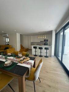 une cuisine et un salon avec une table et des chaises dans l'établissement Casa De Mariposas Viola, à Faro