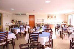 une salle à manger avec des tables et des chaises dans un restaurant dans l'établissement Beira Lago Palace Hotel, à Morrinhos