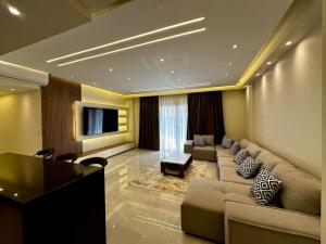 a living room with a couch and a tv at the luxury apartment in Madinaty