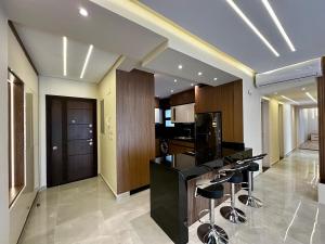 a kitchen with a black counter and some bar stools at the luxury apartment in Madinaty +24 photos