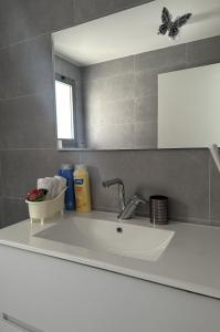 Un lavabo blanco en un baño con espejo. en Red Sea Icon - by G&P Suites, en Eilat 28 fotos más