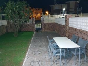 a patio with a table and chairs in a yard at night at APARTAMENTO COSTA CANTABRIA in Cuchia
